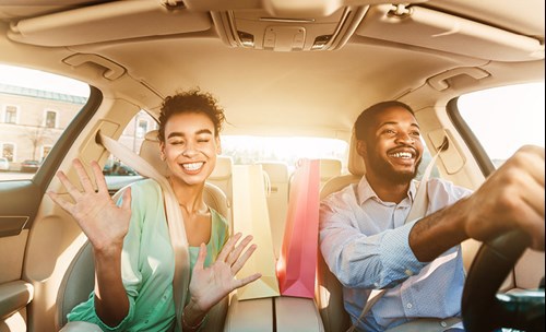 Woman and man smiling in car